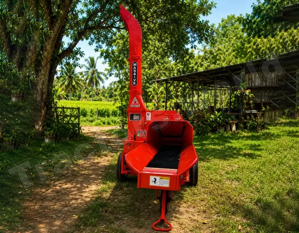 Red wood chipper/shredder on a stand in a sunny garden, with trees and a shed in the background.