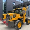 Yellow wheel loader with a raised bucket labeled MASSIVE, parked in front of a modern gray building.